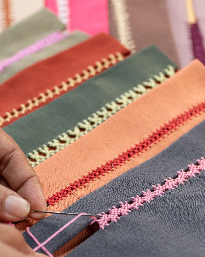 ’n Hand werk dekoratiewe steke op verskillende kleure materiaal